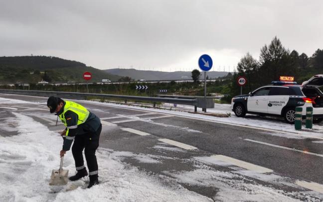 Un agente de la Guardia Civil retira granizo de la calzada con una pala. Redacción DNN Un agente de la Guardia Civil retira granizo de la calzada con una pala. Redacción DNN