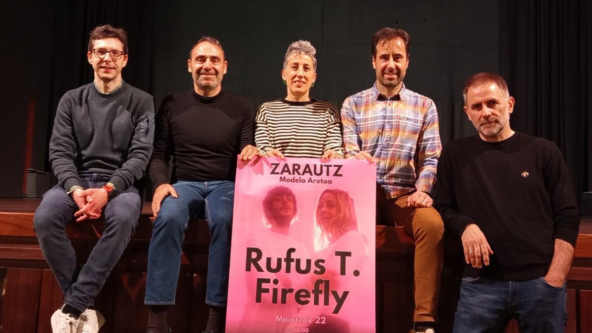 Irune Urbieta, concejala de Cultura, en el centro, y miembros de la asociación I Love Rock con el cartel del concierto.