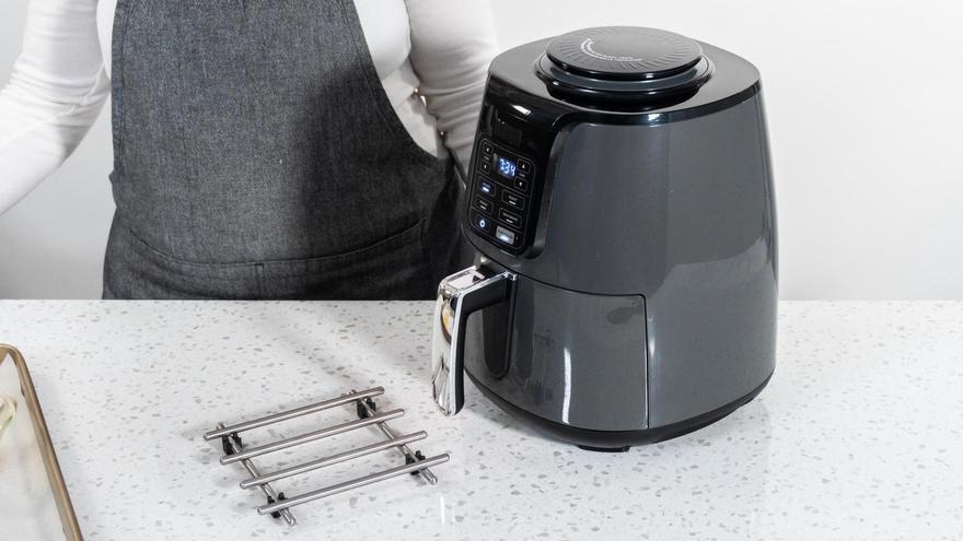 Una cocinera prepara un a freidora de aire.