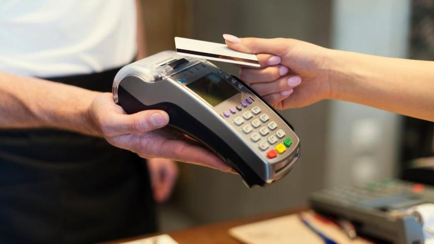 Imagen de archivo de una tarjeta de crédito realizando un pago a través de un datáfono