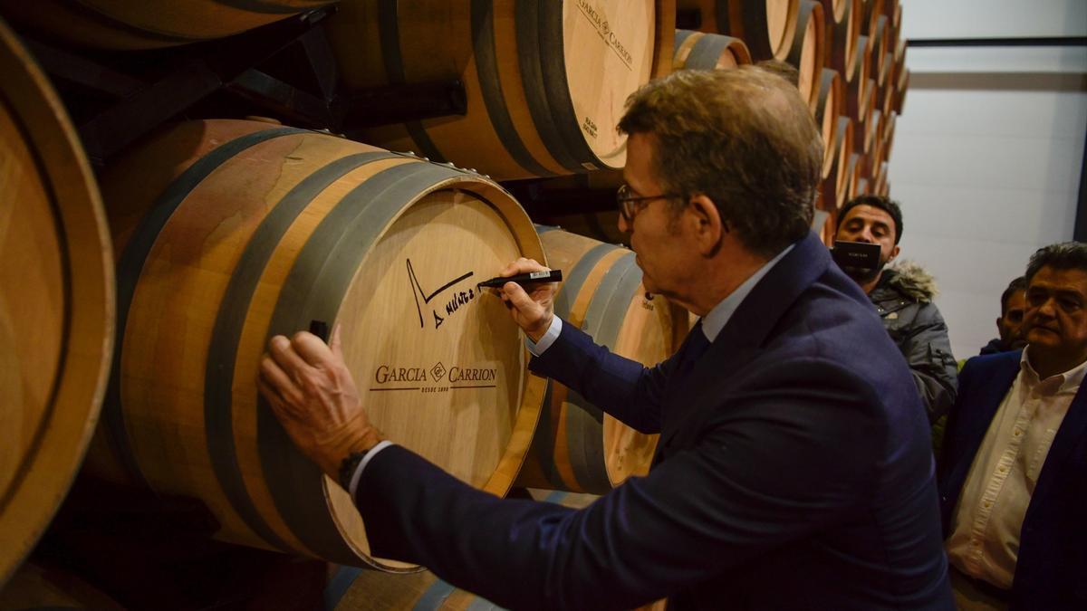 Feijóo, firmando en una barrica de vino.