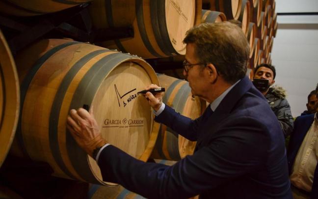 Feijóo, firmando en una barrica de vino.