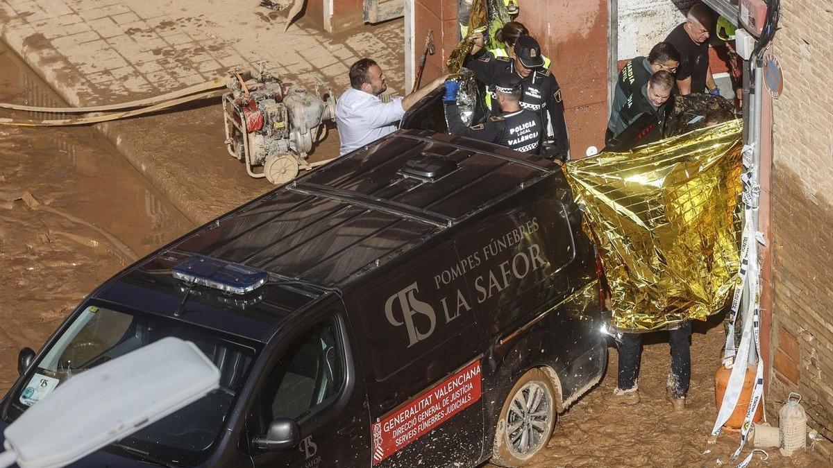 Un furgón de la funeraria sale de un garaje con cadáveres localizados tras el paso de la DANA