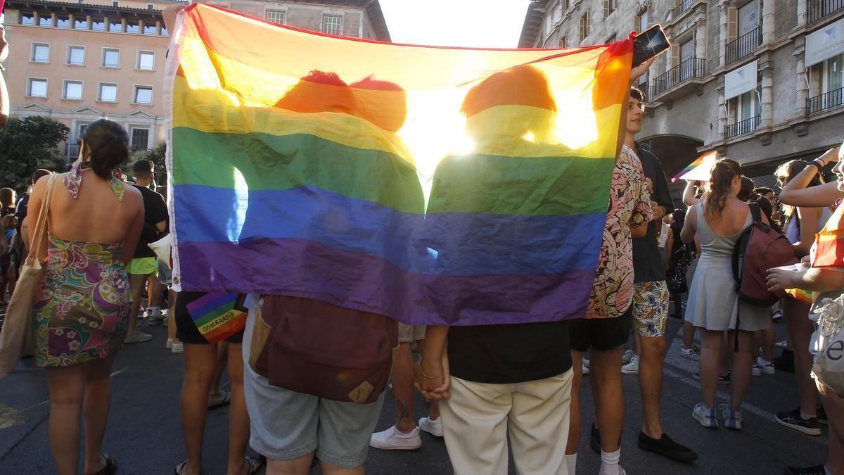 Dos personas se tapan con una bandera durante una manifestación por el Orgullo LGTBI