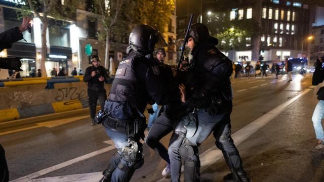 Varios antidisturbios deteniendo manifestantes, durante una manifestación contra la amnistía frente a la sede del PSOE en Ferraz este jueves.