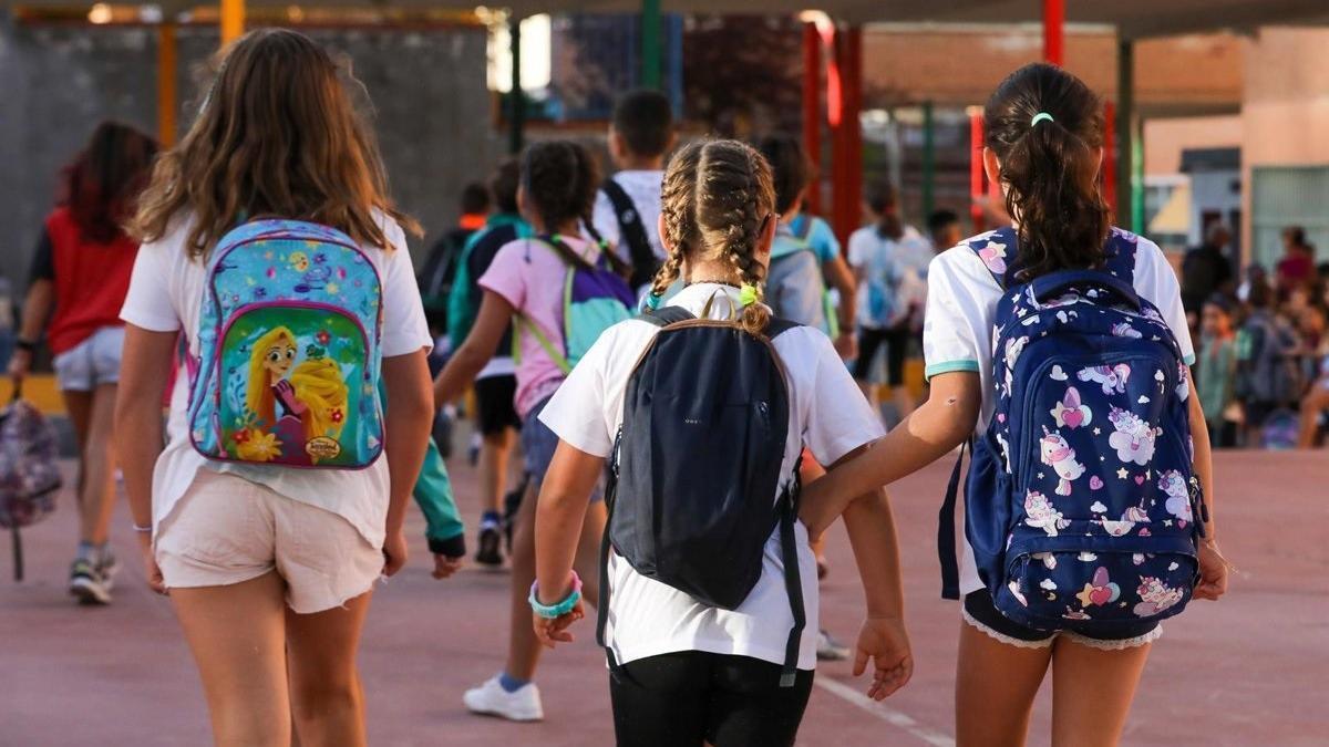 Tres niñas a su llegada a un colegio durante el primer día del curso escolar.