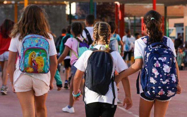 Tres niñas a su llegada a un colegio durante el primer día del curso escolar.