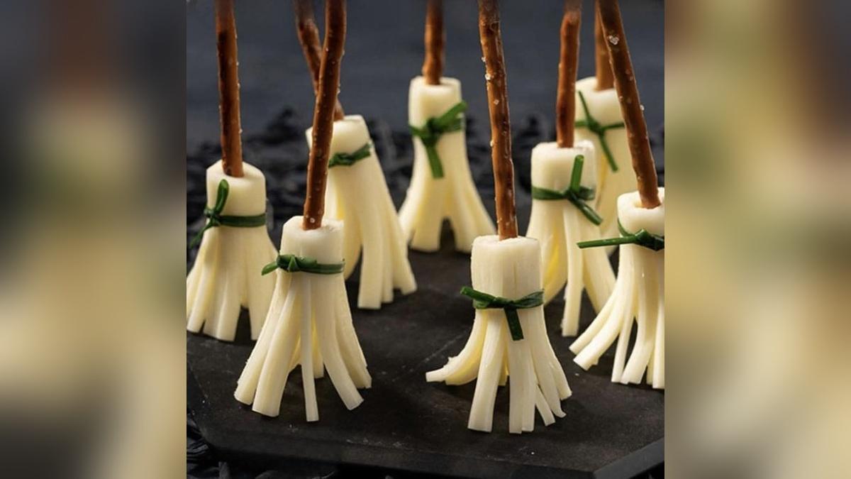 Escobas de bruja elaboradas con queso, palitos salados y cebollino.
