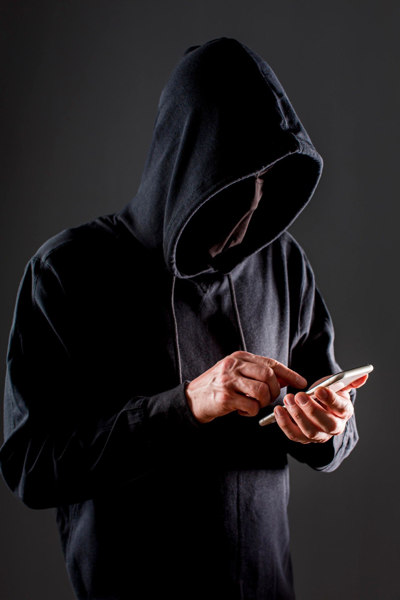 Un pirata informático manipula un teléfono inteligente.
