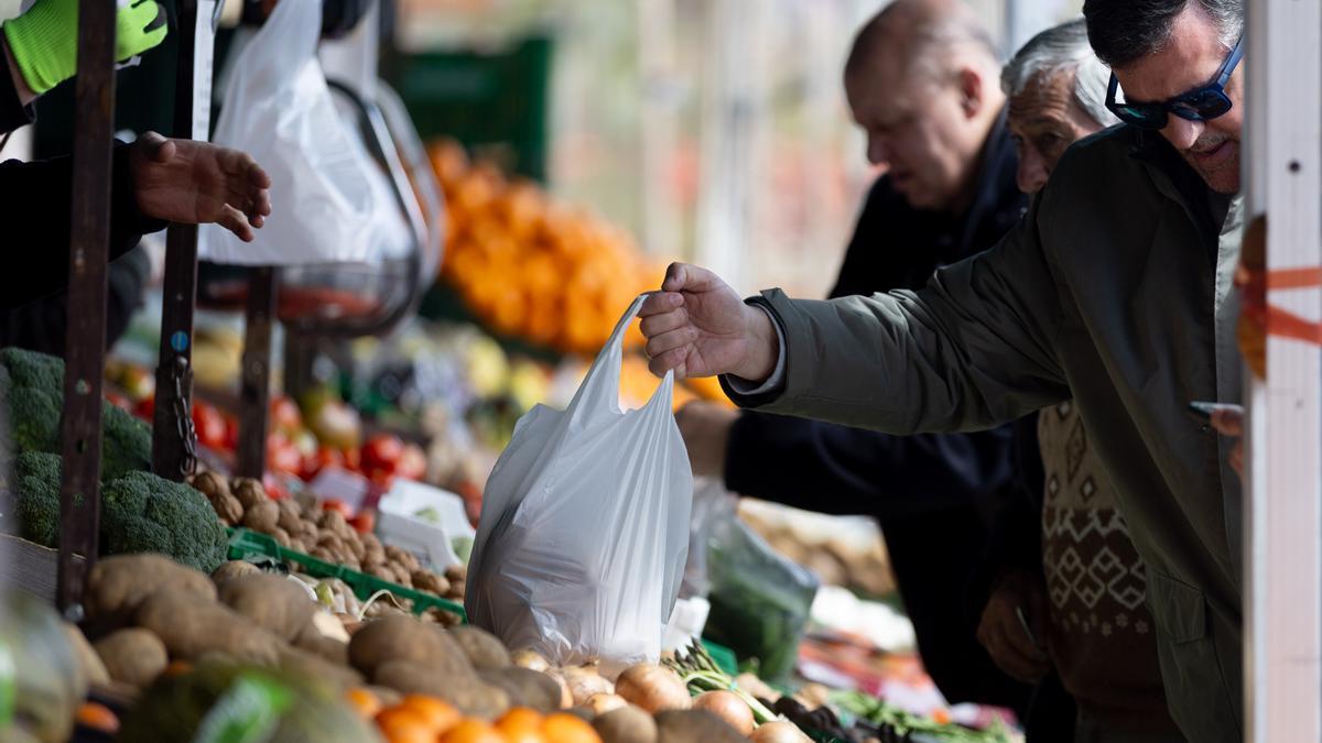 Varias personas compran en un mercado de alimentos