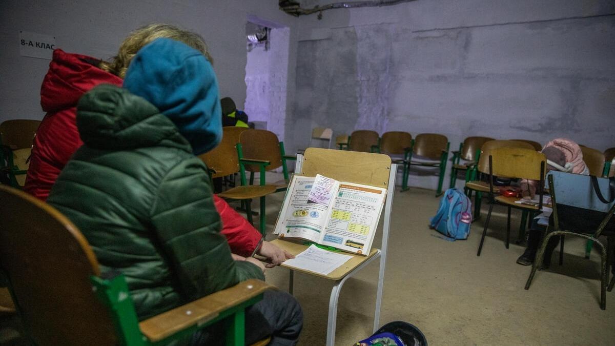 Una maestra explica las tareas a un estudiante mientras se refugia en el sótano de una escuela en Chernígov.
