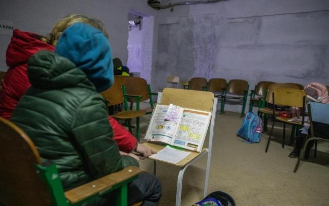 Una maestra explica las tareas a un estudiante mientras se refugia en el sótano de una escuela en Chernígov.