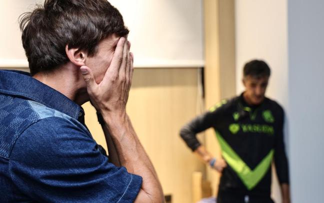 Le Normand se lleva las manos a la cara, con Imanol de fondo, en su despedida de ayer en Zubieta. / REAL SOCIEDAD