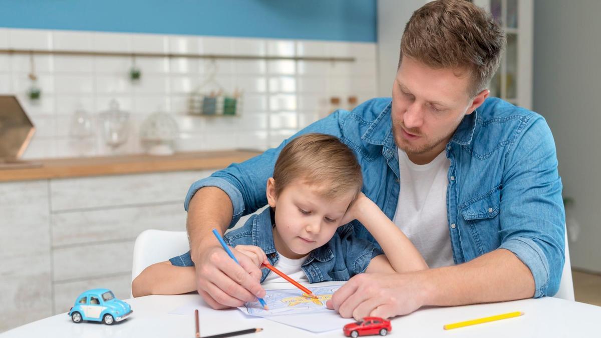 Un padre ayuda a su hijo a pintar un dibujo.