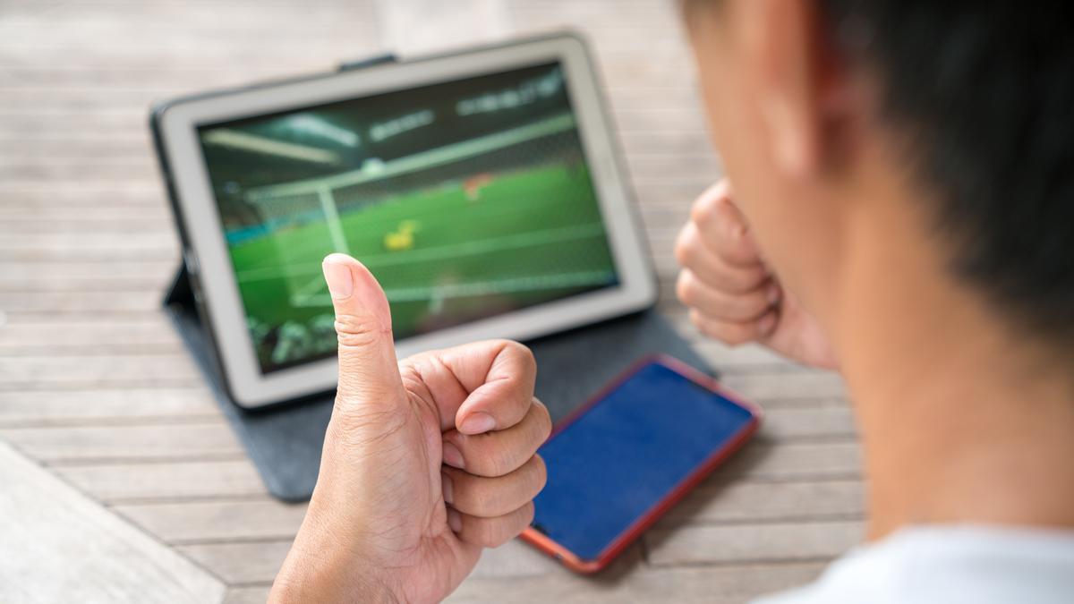 Una persona ve un partido de fútbol en una tablet.