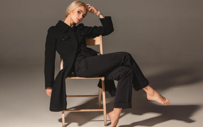 Una mujer muy elegante con abrigo y pantalón negro.