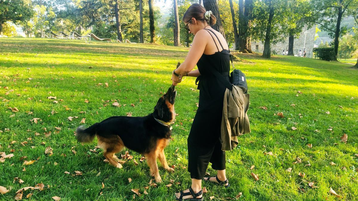 Una joven juega con su perro en un parque.