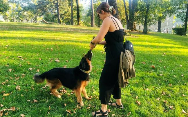Una joven juega con su perro en un parque.