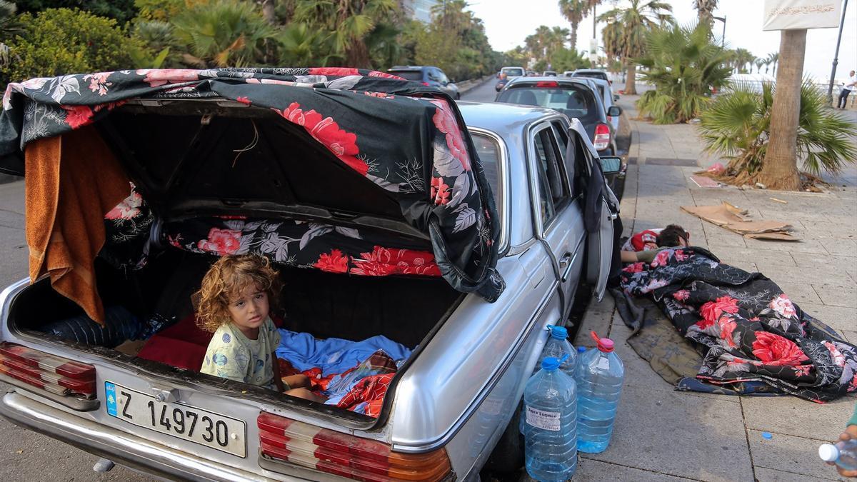 Un niño se refugia en el maletero de un coche en Líbano.