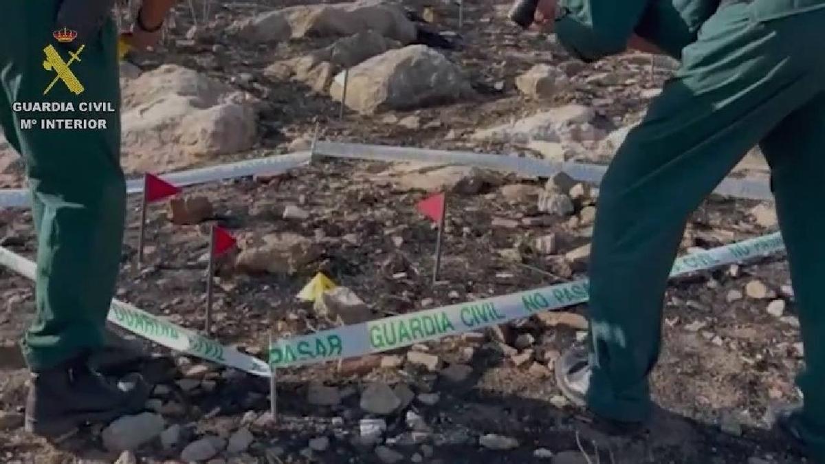 Dos agentes de la Guardia Civil inspeccionan uno de los puntos incendiados por el detenido en Teba (Málaga).