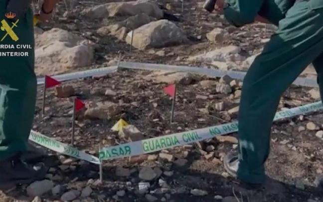 Dos agentes de la Guardia Civil inspeccionan uno de los puntos incendiados por el detenido en Teba (Málaga).