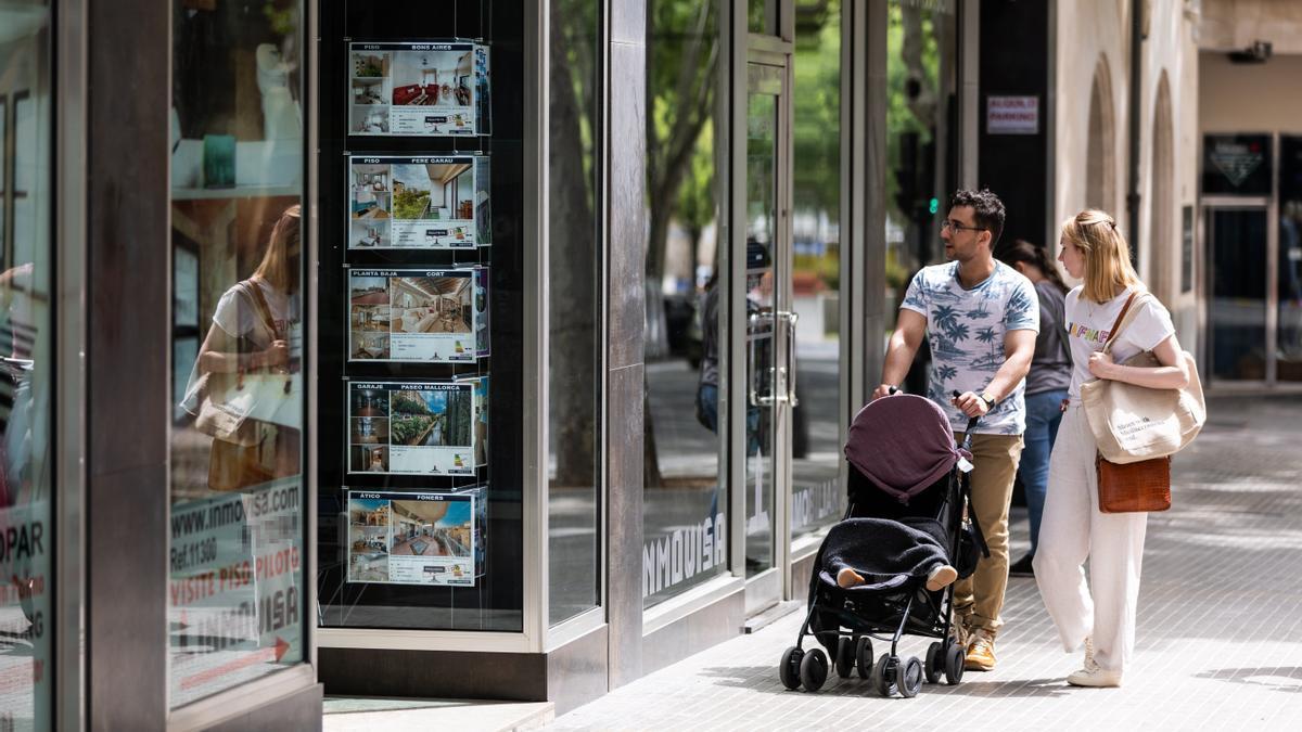 Una pareja mira pisos en una inmobiliaria.