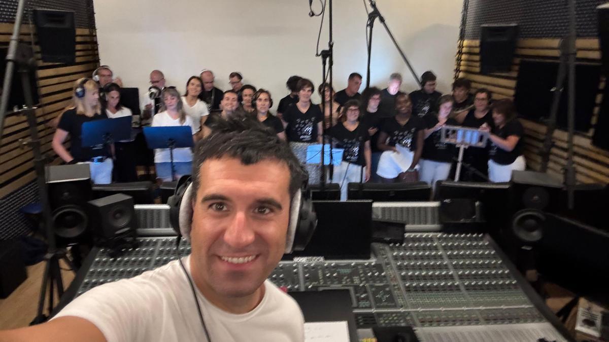 El director de Ganbara, Aitor Biain, y las y los integrantes de la coral durante la grabación.