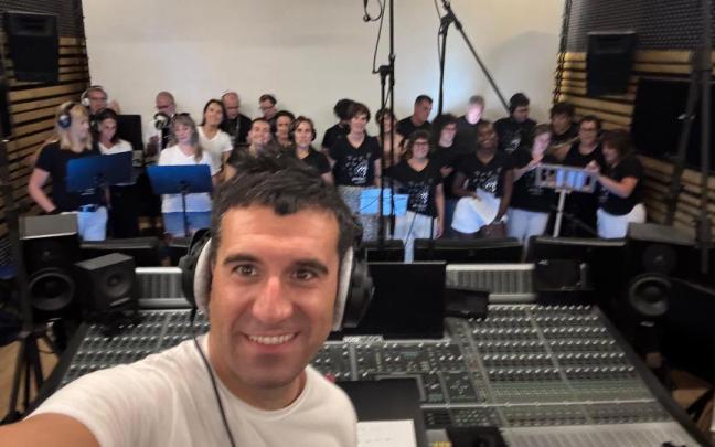 El director de Ganbara, Aitor Biain, y las y los integrantes de la coral durante la grabación.