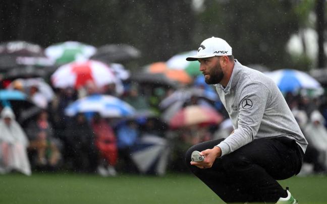Jon Rahm observa en el green 18.