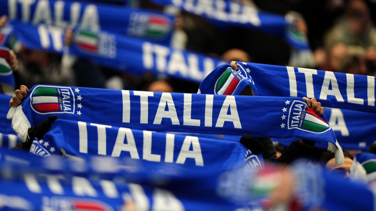 Aficionados italianos sostienen las bufandas en alto durante un partido de su selección.