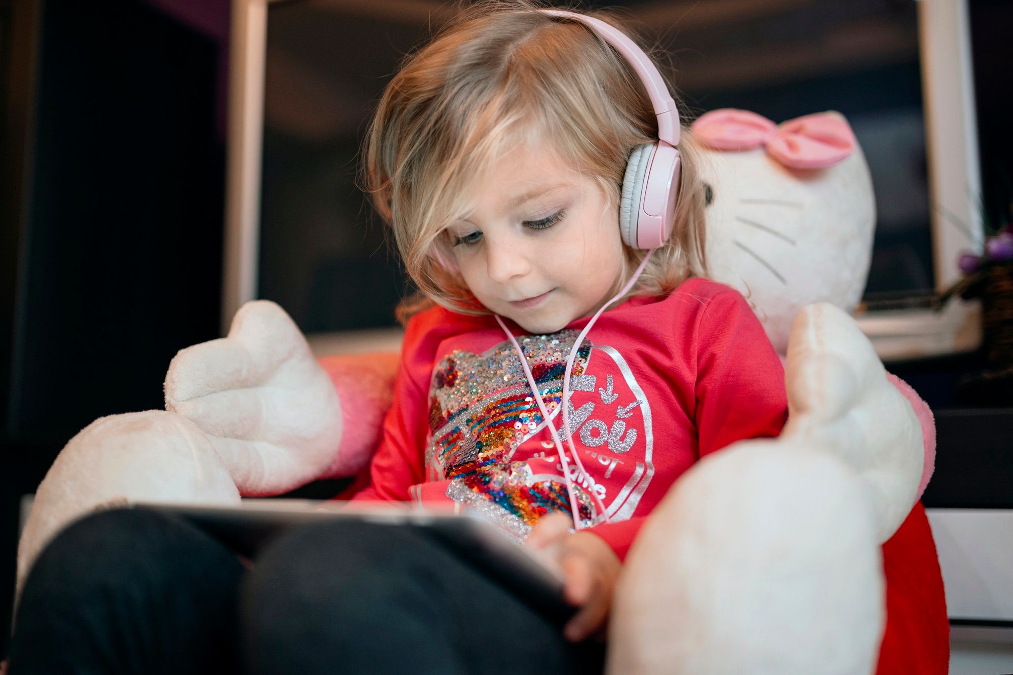 Una niña lleva cascos para jugar con la tablet.