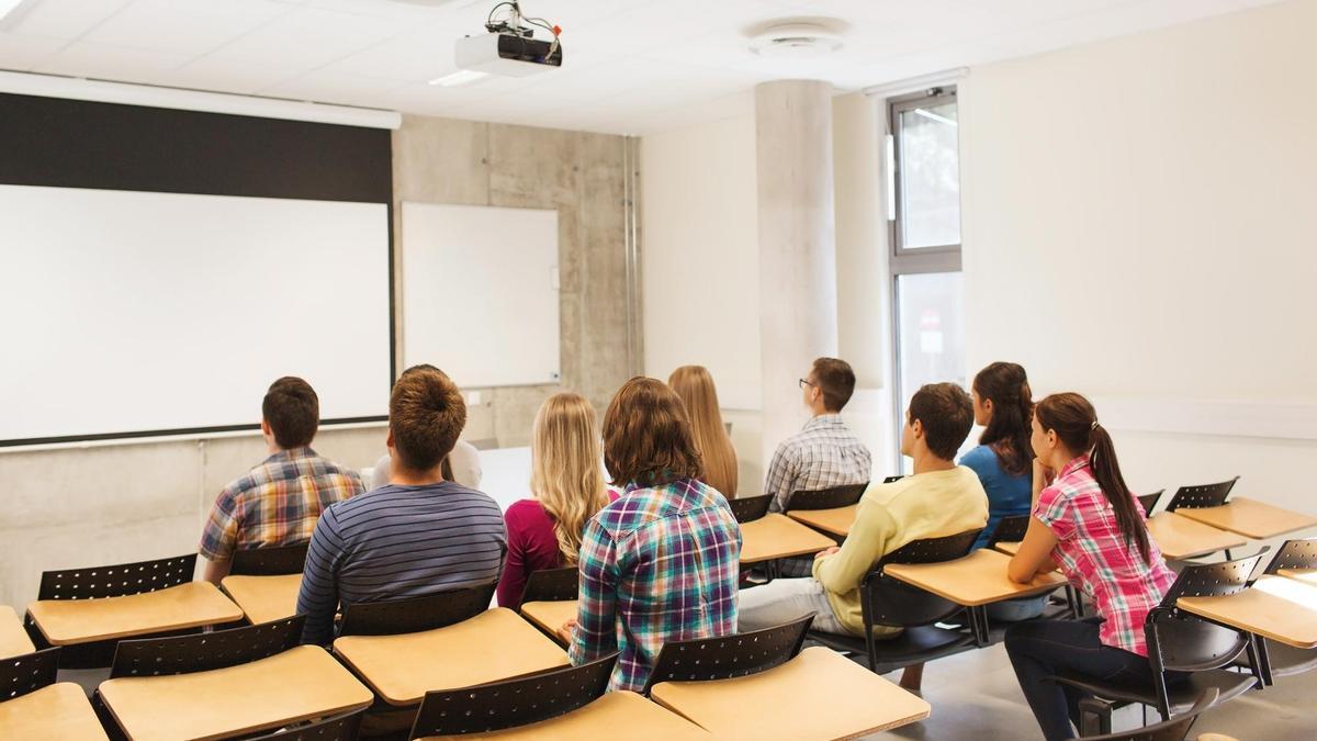 Jóvenes universitarios, de espaldas en un aula.