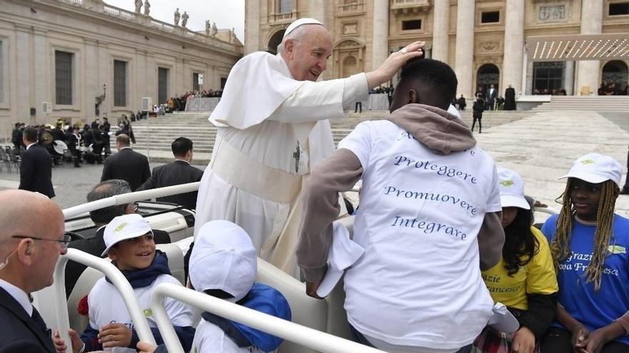 Francisco junto a varios inmigrantes en el Vaticano.
