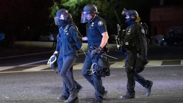 Policías se llevan arrestada a una manifestante en Portland.