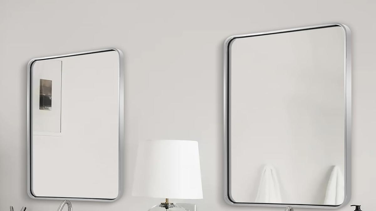 Dos espejos rectangulares dan amplitud al baño.