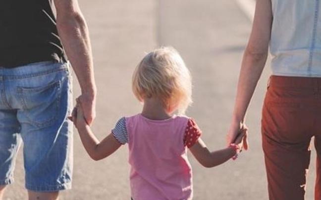 Una niña coge a sus padres de la mano. / EP Una niña coge a sus padres de la mano.