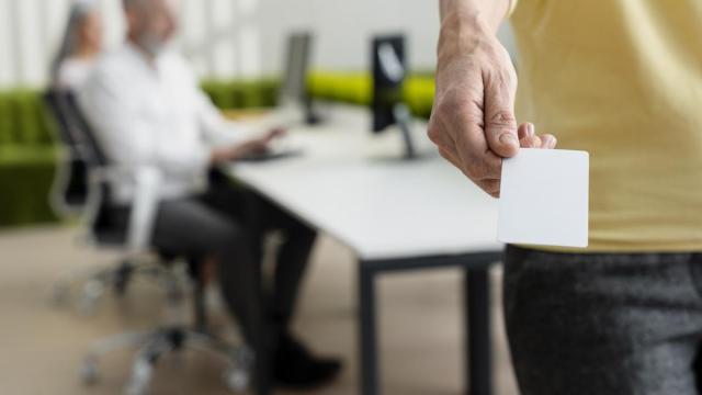 Una mujer sostiene la tarjeta con la que registra su jornada laboral