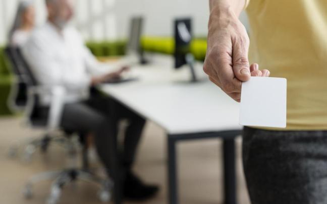 Una mujer sostiene la tarjeta con la que registra su jornada laboral