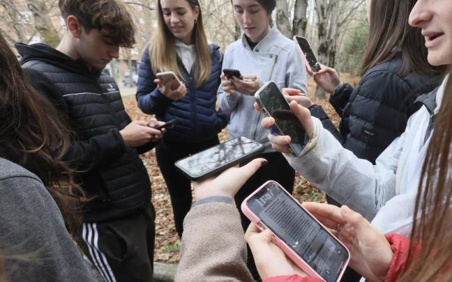 Varios jóvenes comprueban mensajes en sus móviles