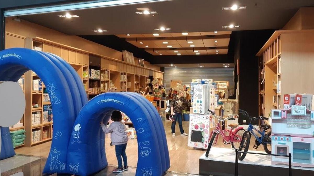 Una niña pasa por la puerta pequeña de una tienda de Imaginarium.