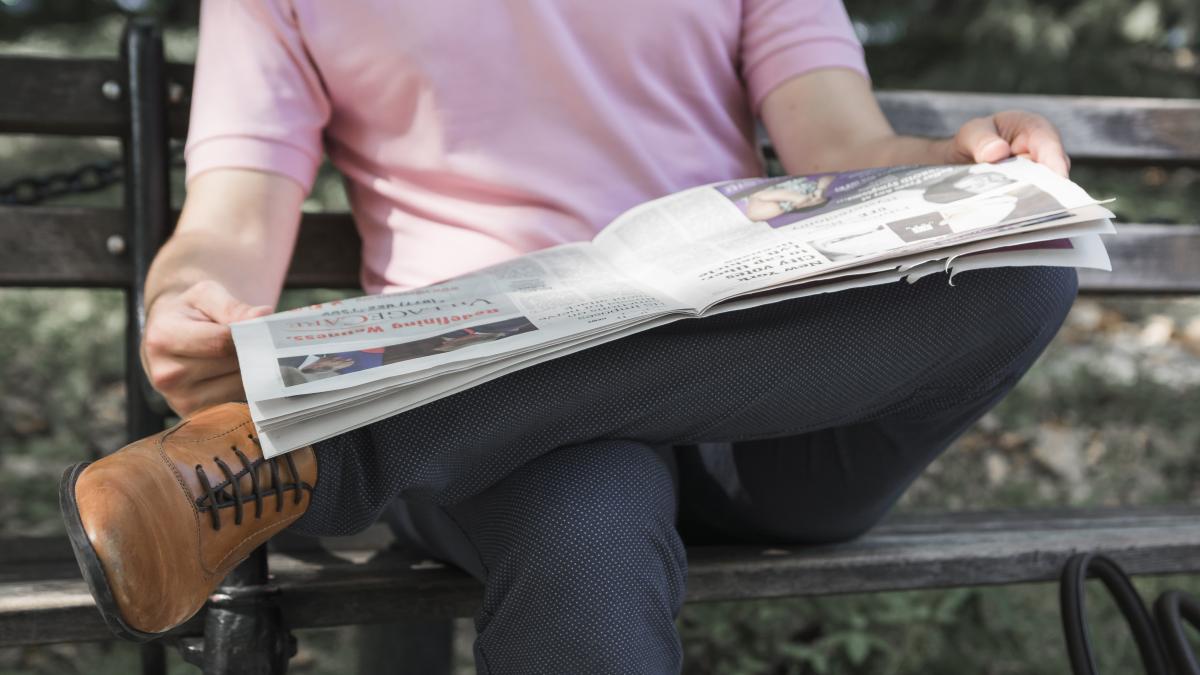 Una persona leyendo un periódico. FREEPIK