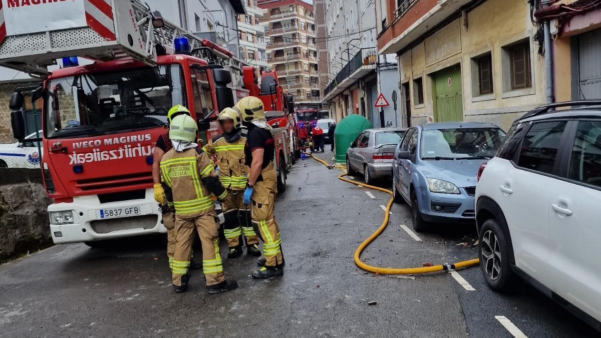 Bomberos junto a la vivienda incendiada en Bermeo. CRUZ ROJA BIZKAIA