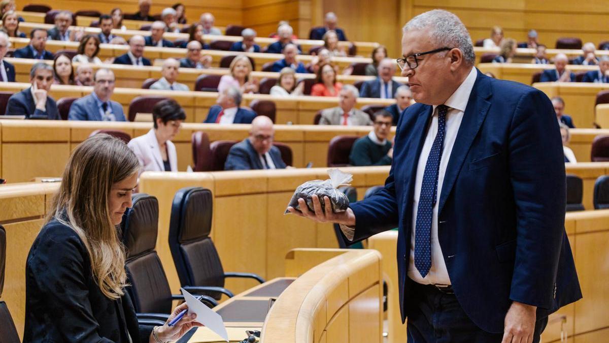 Momento en el que el senador del PP Francisco Bernabé entrega la bolsa a Aagesen.