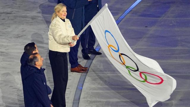 Kirsty Coventry, presidente del Comité Olímpico Internacional, ondea la bandera de los Juegos Olímpicos.