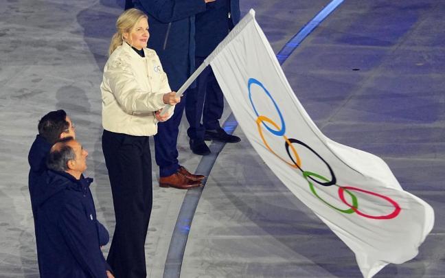 Kirsty Coventry, presidente del Comité Olímpico Internacional, ondea la bandera de los Juegos Olímpicos.