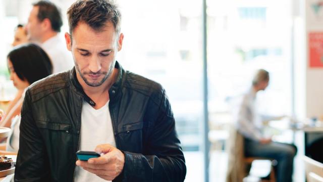 Un hombre hace un bizum con su móvil.