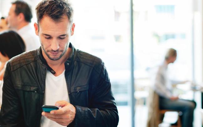 Un hombre hace un bizum con su móvil.