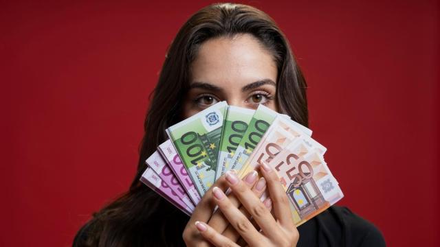 Una mujer sostiene en sus manos billetes de euro de distinto valor. Una mujer sostiene en sus manos billetes de euro de distinto valor.