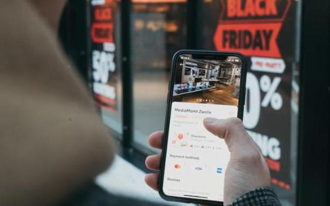 Una persona realizando una compra por internet desde su teléfono móvil Una persona realizando una compra por internet desde su teléfono móvil
