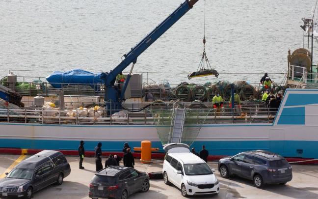 Operarios bajan con la ayuda de una grúa a una de las personas fallecidas en el naufragio del buque gallego. Operarios bajan con la ayuda de una grúa a una de las personas fallecidas en el naufragio del buque gallego.